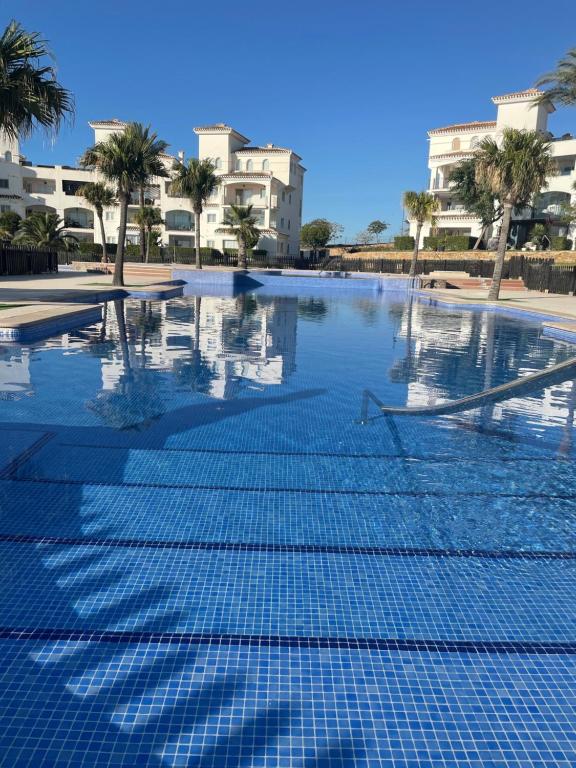 an empty swimming pool with palm trees and buildings at Casa Serena - Sucina in Sucina