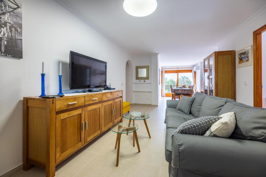 a living room with a couch and a flat screen tv at LAS COLUMNAS in Port de Pollensa