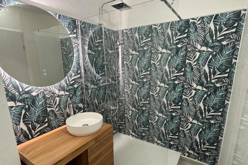 baño con pared estampada en blanco y negro en L'écrin du Rivage, en Sainte-Anne