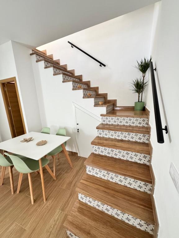 eine Treppe in einem Haus mit einem Tisch und einem Tisch und Stühlen in der Unterkunft La Casita de San Benito in Cazalla de la Sierra