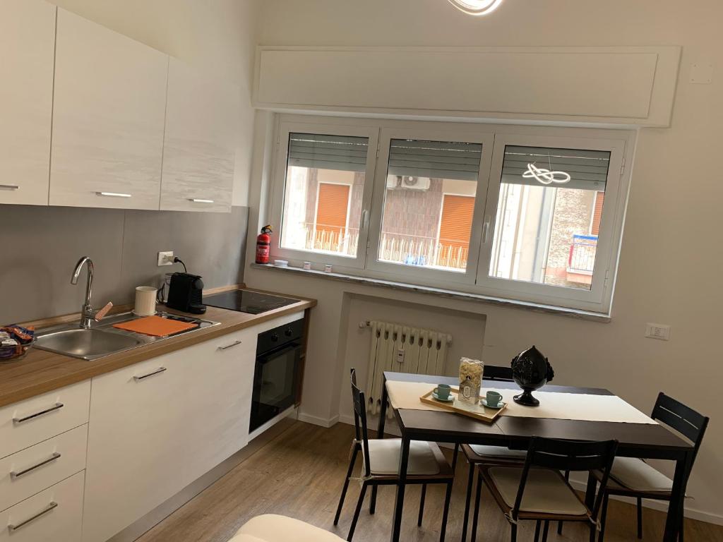 una cucina con tavolo, sedie e lavandino di Pizzoli Suite a Bari