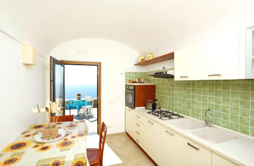 una cucina con tavolo e vista sull'oceano di L'Olimpo casa vacanze a Conca dei Marini