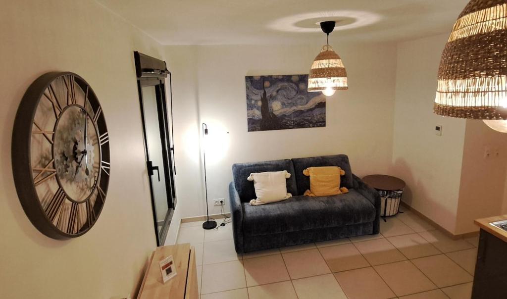 un salon avec un canapé et une horloge au mur dans l'établissement L'Atelier Rochecardon, à Lyon