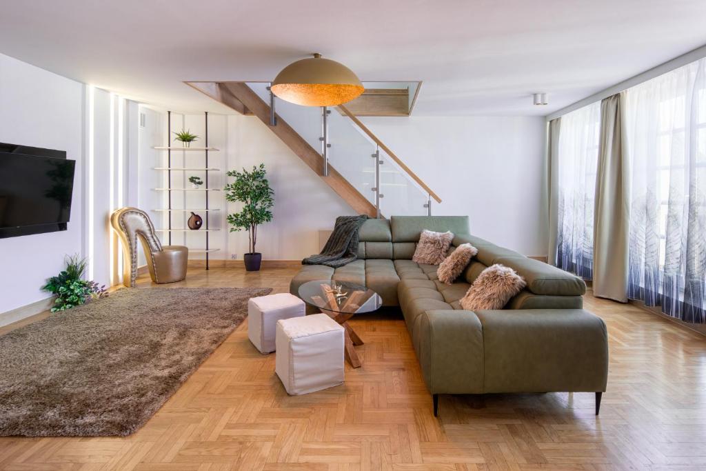 a living room with a green couch and a staircase at Apartament w centrum - duplex penthouse in the centre with terrace and air conditioning in Krakow