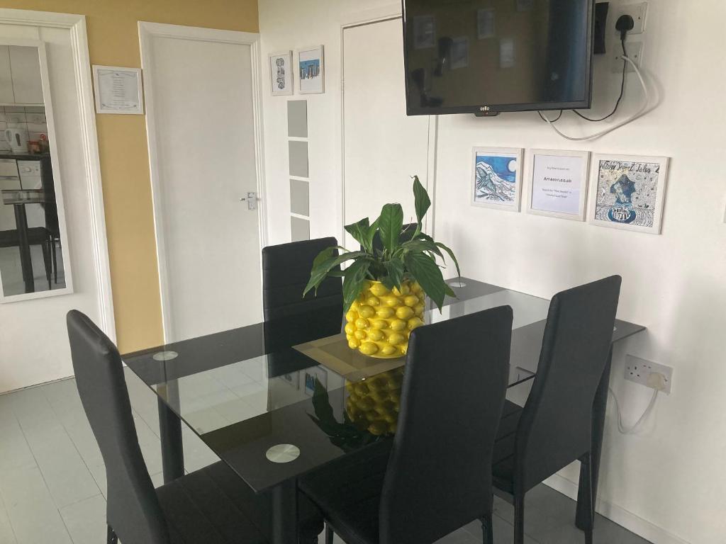 a dining room with a glass table with a pineapple on it at Chalet K118 - The Sand Beach in Camber