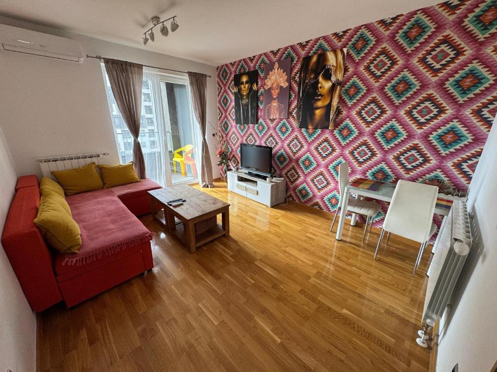 a living room with a red couch and a table at Sarajevo Bulevar in Sarajevo