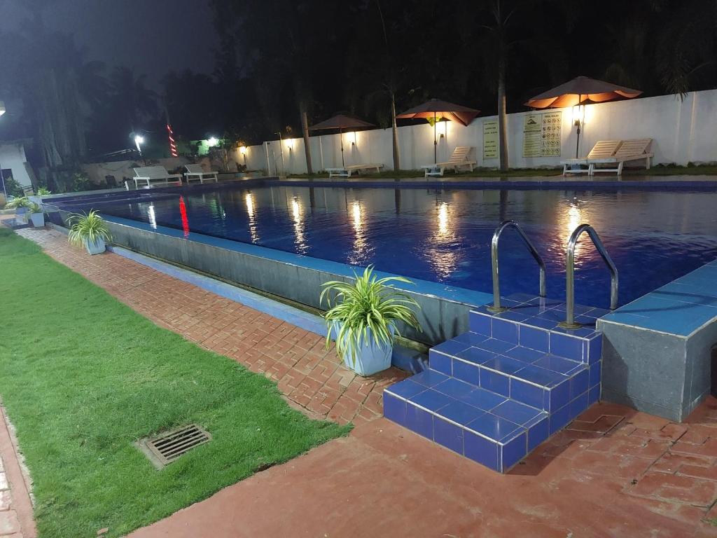 a large swimming pool at night with blue tiles in it at MRD Beach Hotel in Trincomalee