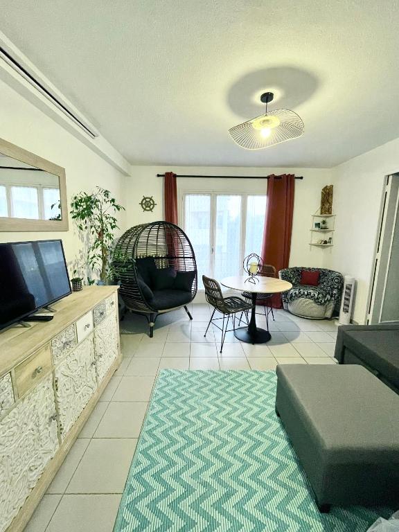 un salon avec une télévision, un canapé et une table dans l'établissement Les Pins d'Antibes, à Antibes