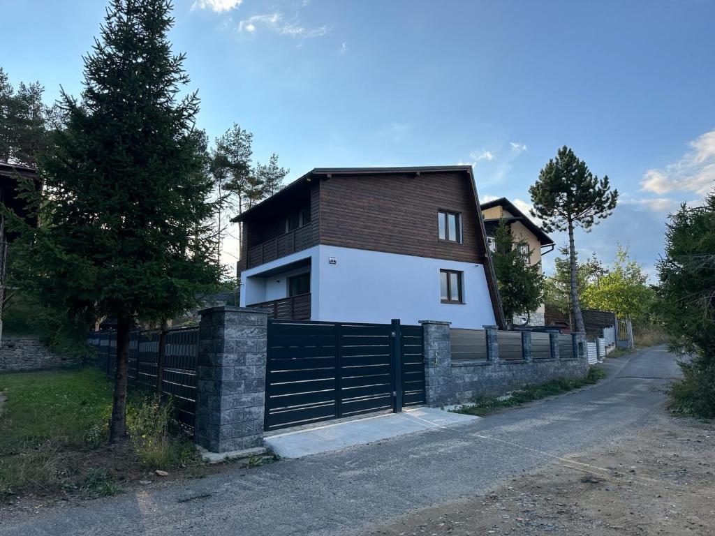 a house with a fence next to a road at Chata ARMA in Vrbov