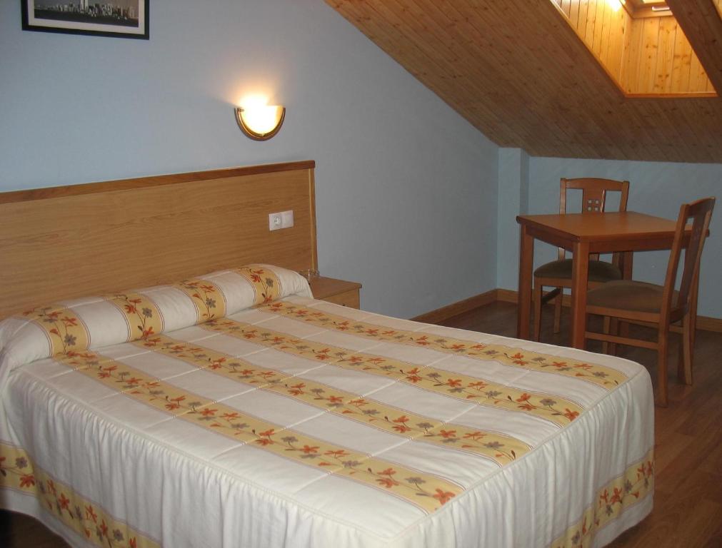 1 dormitorio con 1 cama, 1 mesa y 1 silla en Hotel Reyes De León en Santa María del Páramo