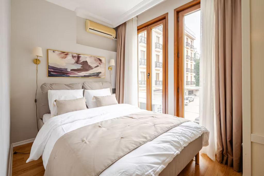a bedroom with a large white bed and a window at Raya Cihangir Suites in Istanbul