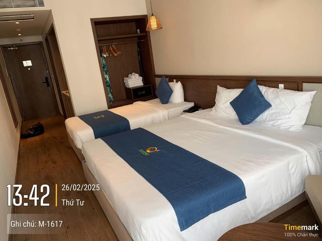 two beds in a hotel room with blue and white at APEC MANDANA CHAM BAY Mũi Né in Ấp Thiẹn Ái
