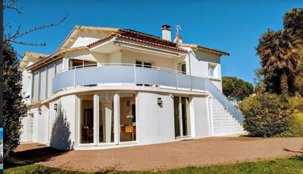 une maison blanche avec un balcon au-dessus dans l'établissement Les Portes de l'Océan, à Vaux-sur-Mer