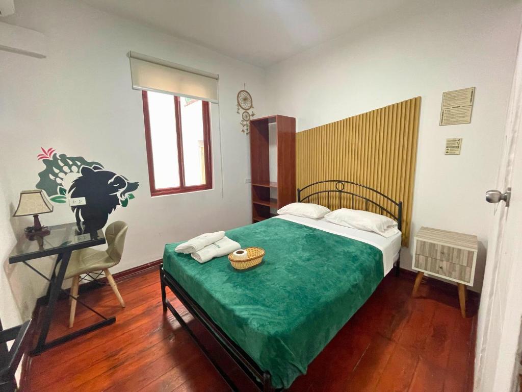 Un dormitorio con una cama, una mesa y una silla. en Hostel Prada, en Lima