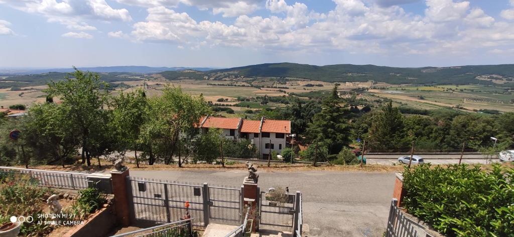 a house on a hill with a fence and a road at CASA ALLE COSTE camere con vista in Massa Marittima