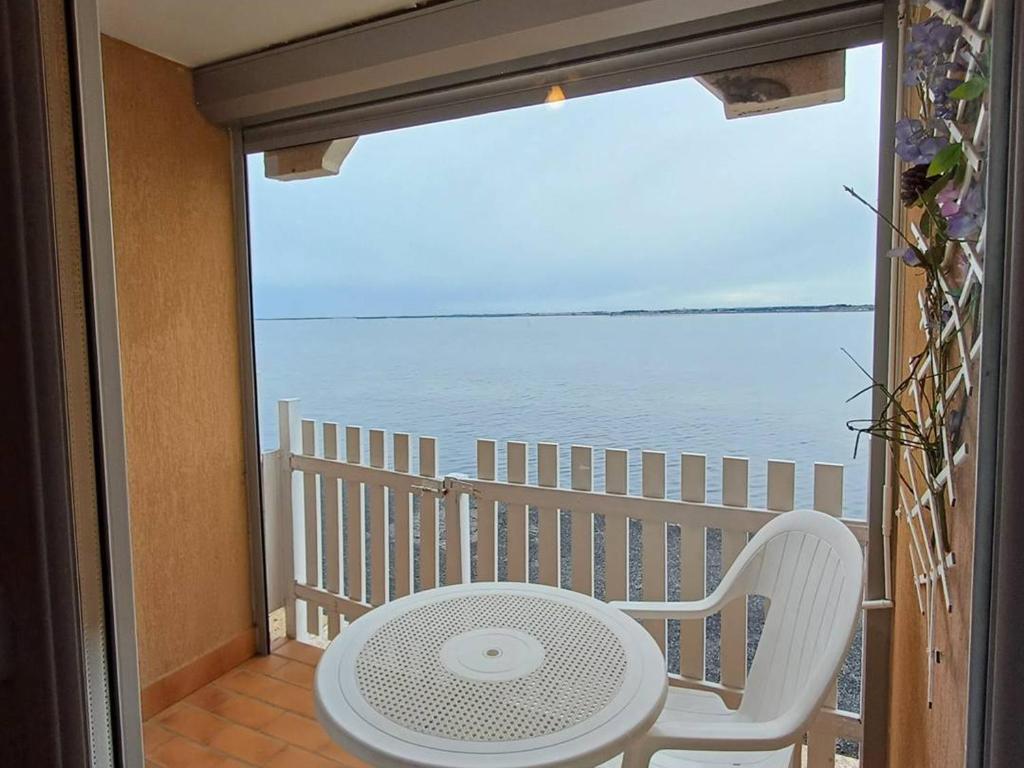 d'une table et d'une chaise sur un balcon donnant sur l'océan. dans l'établissement Agréable studio avec loggia et animaux acceptés – Balaruc-les-Bains - FR-1-571-38, à Balaruc-les-Bains