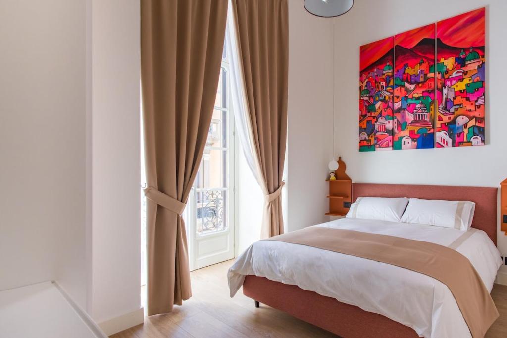 a bedroom with a bed and a painting on the wall at My Lodge Italy - Style and Comfort in Naples