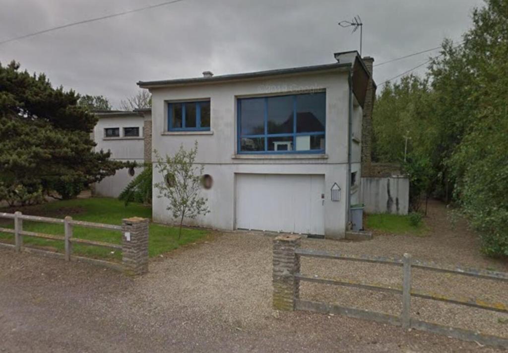 une maison blanche avec une clôture devant dans l'établissement Le Radeau Maison 50m de la Mer - 6P - 3 Chambres 2 SDB, à Ver-sur-Mer