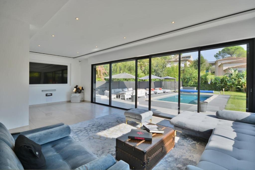 - un salon avec un canapé, une table et une piscine dans l'établissement Villa Bella Vista - Luxe - Piscine et Sérénité au Cœur du Cannet, au Cannet