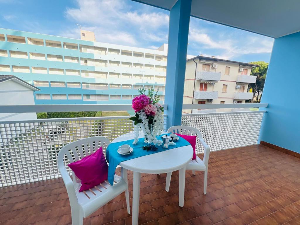 - Balcón con mesa blanca y sillas en Condominio Athena, en Bibione