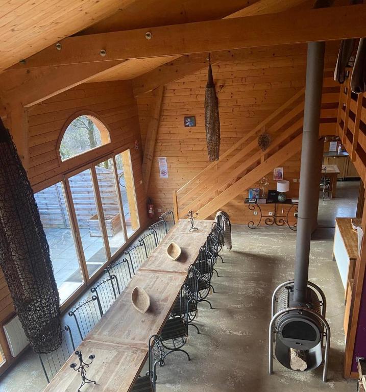 une longue table en bois avec des chaises dans une cabine dans l'établissement LE GîTE DES DAINES, à Lavans-lès-Saint-Claude