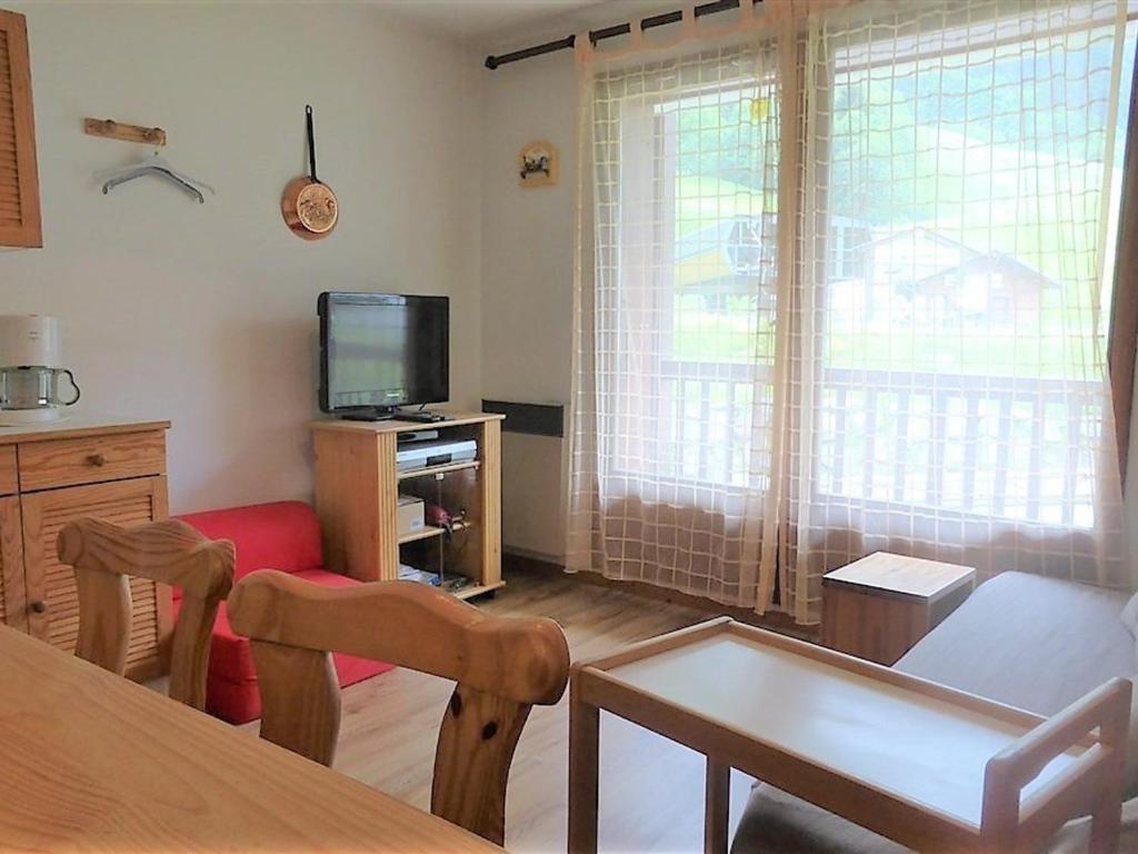 un salon avec une table et une télévision dans l'établissement Petit cocon 2* au pied des pistes, 4/5 pers., parking, wifi, animaux admis, Arêches-Beaufort - FR-1-342-247, à Beaufort
