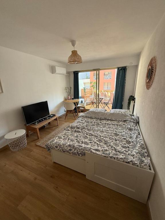 une chambre avec un lit et une télévision dans l'établissement Bohemian studio in Menton close to sea with parking, à Menton
