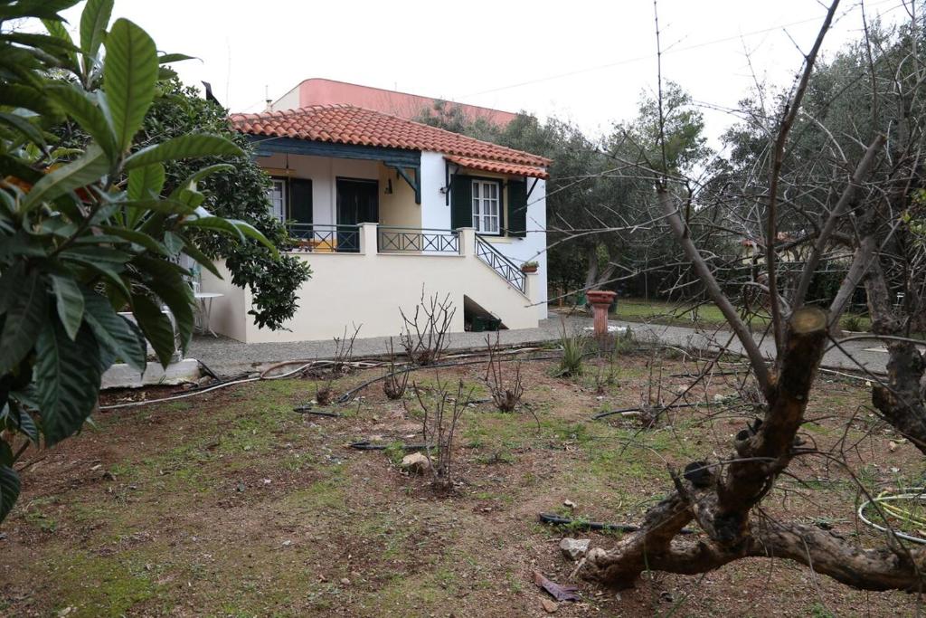 a white house with a balcony in a yard at Babis Garden Salamina in Selínia