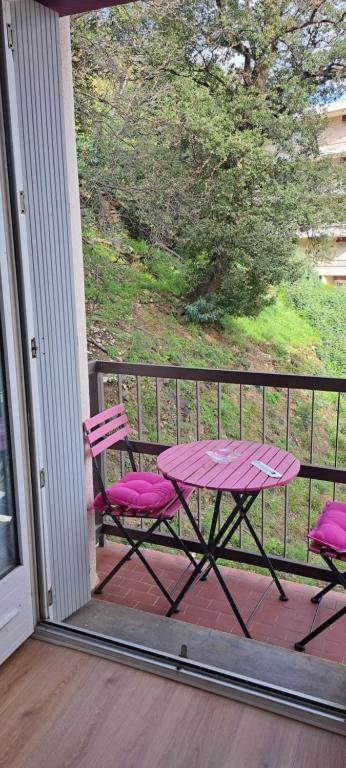 une table de pique-nique et deux chaises sur un porche dans l'établissement Agréable et frais au Nord joli studio Sophie rénové wifi parking balcon, à Amélie-les-Bains-Palalda
