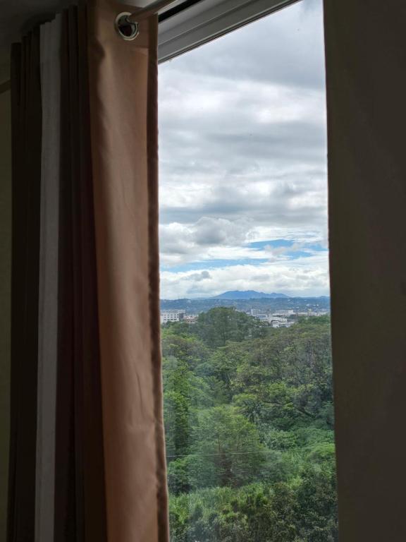 a window with a view of a forest at Casa de Porch in Manila