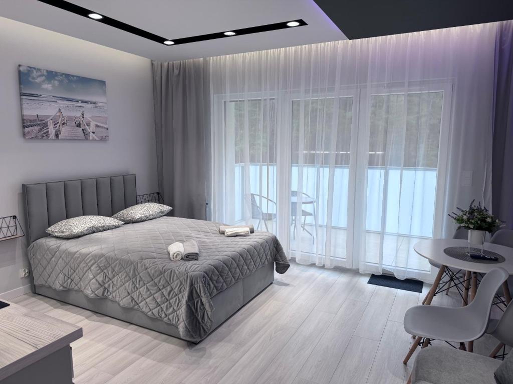 Un dormitorio con una cama y una mesa y sillas. en APARTAMENT Słoneczna 28 - POGORZELICA, en Pogorzelica