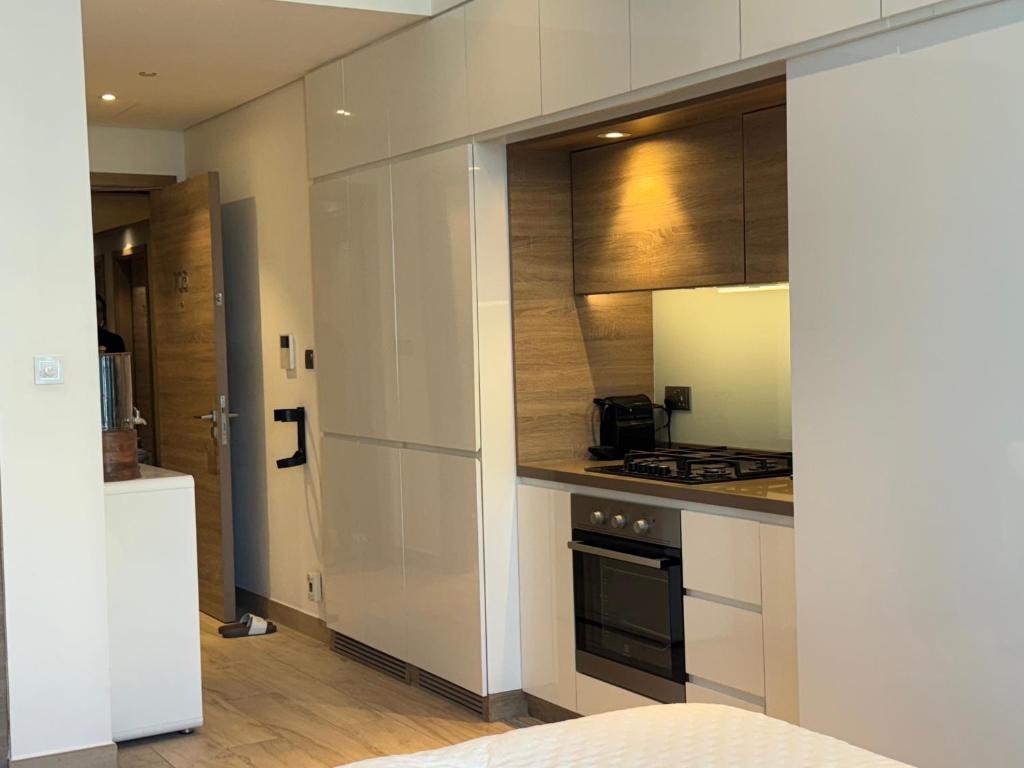 una cucina con armadietti bianchi e piano cottura di Studio One Dubai Marina - TIE Vacation Homes a Dubai