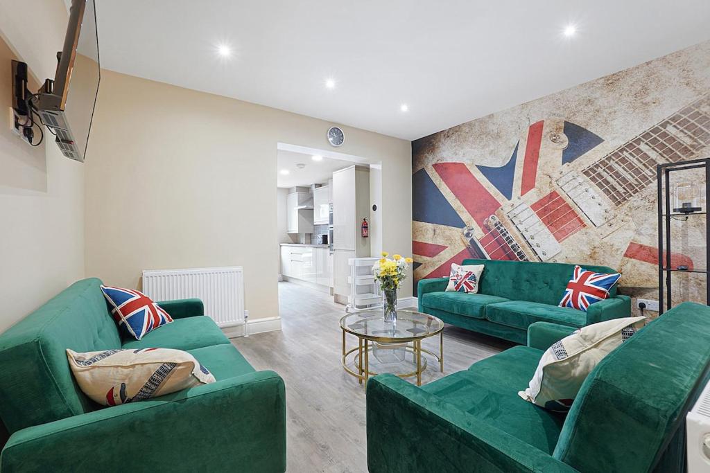 a living room with two green couches and a table at OnSiteStays - Stylish 5 bedroom house with 3 bathrooms in Dartford