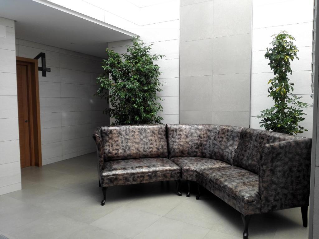 a couch in a room with plants on the wall at Apartamentos Las Palmeras in Palma del Río