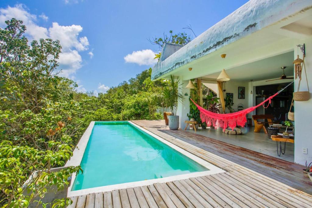 a house with a swimming pool on a wooden deck at Casa Dahomey in Pipa