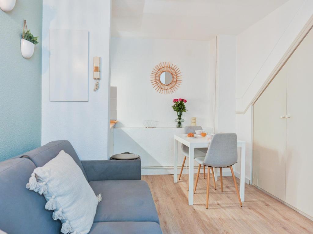 un salon avec un canapé bleu et une table dans l'établissement Charmant Duplex Montpellier - City Center, à Montpellier