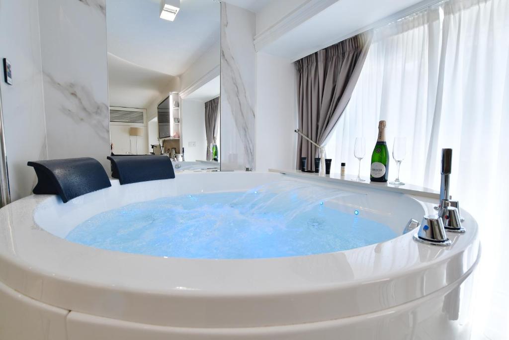 a large tub in a room with a bottle of wine at Domus De Cinti in Tivoli