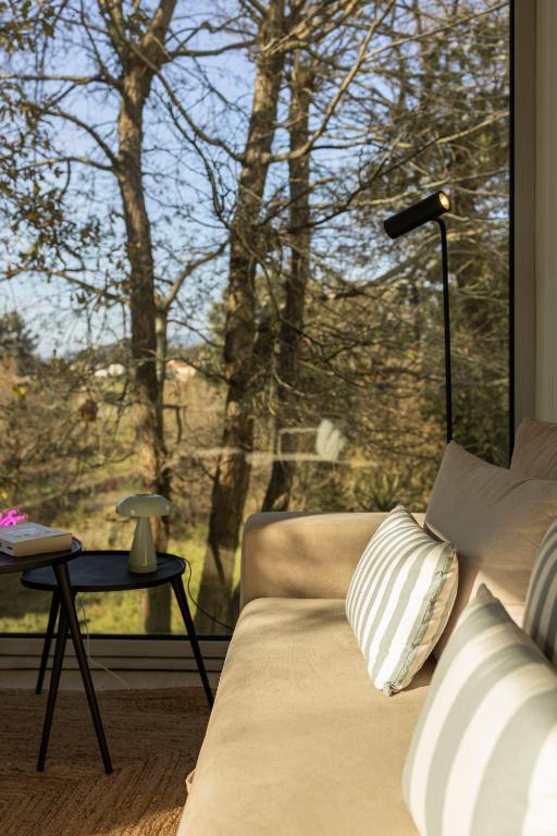 a living room with a couch and a large window at Bisas Villa in Caminha