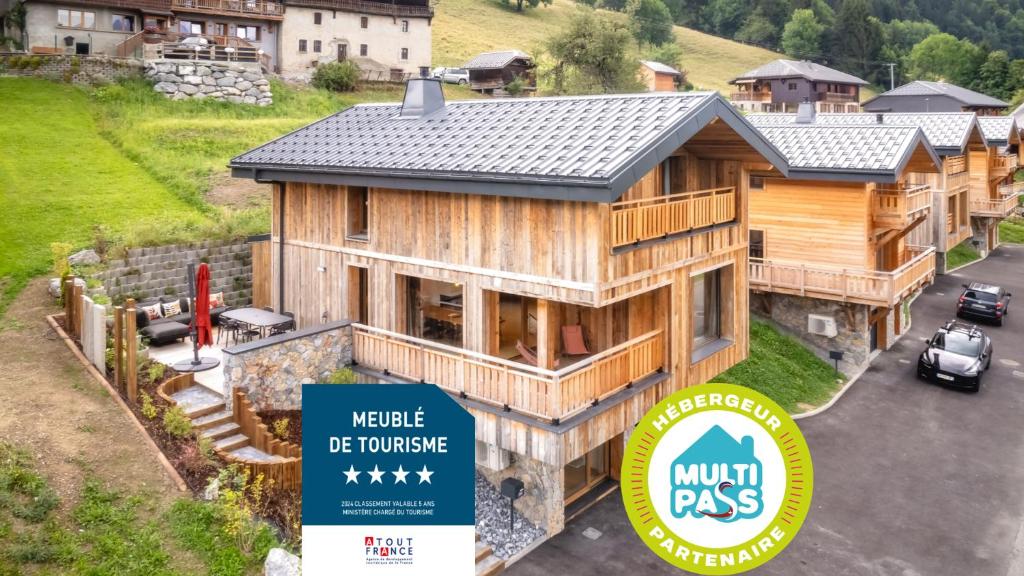 une grande maison en bois avec un panneau en face de celle-ci dans l'établissement Chalet l'Alisier - Modern chalet, beautiful mountain view, Morzine-Les Gets, à La Côte dʼArbroz