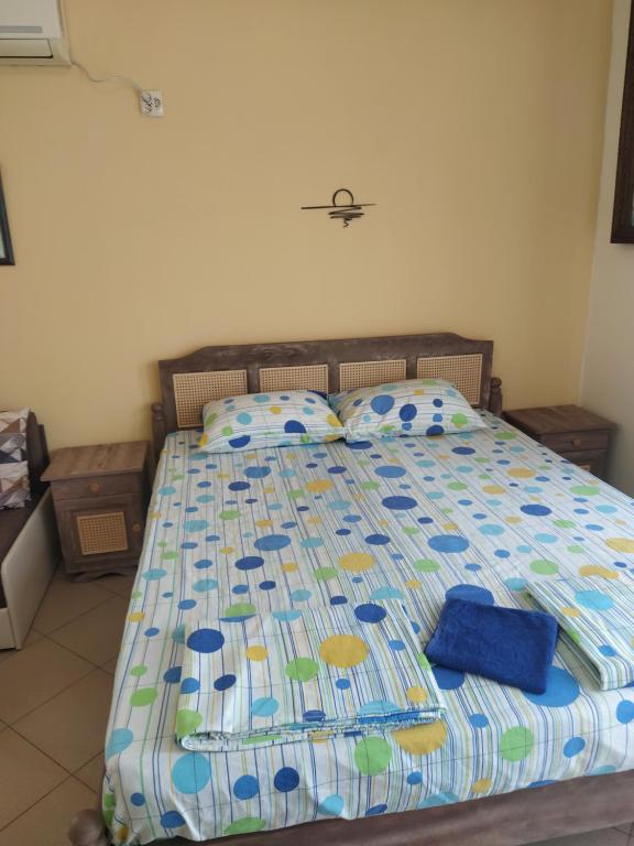 a bed with a blue comforter and pillows on it at Апартамент - студио в кв Сарафово с морски изглед in Burgas City