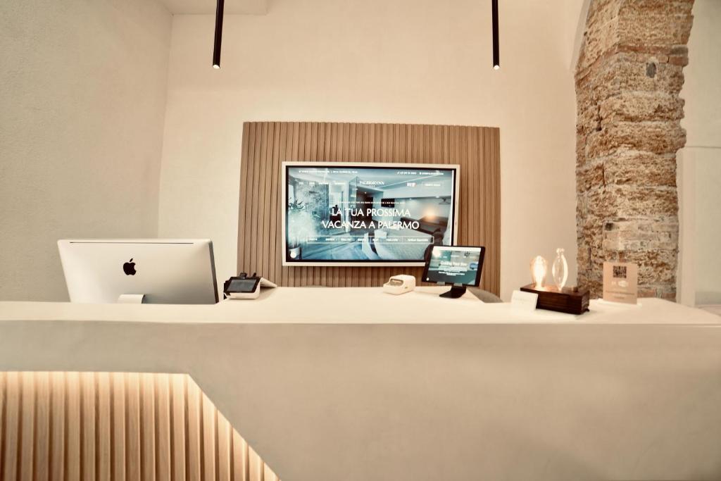 an office with a desk with a computer and a laptop at Palermo Inn Boutique Arte in Palermo