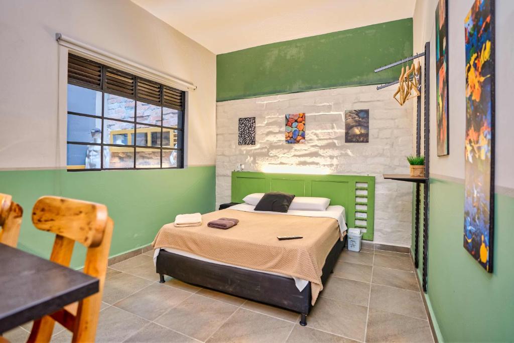 a bedroom with a bed and a green wall at La Gruta Coliving in Medellín