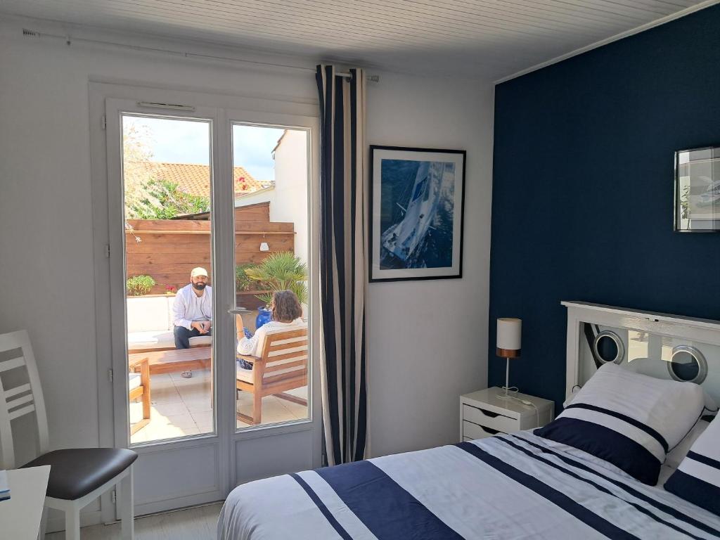 - une chambre avec un lit et une porte coulissante en verre avec une terrasse dans l'établissement Les portes du soleil, à Les Sables-dʼOlonne