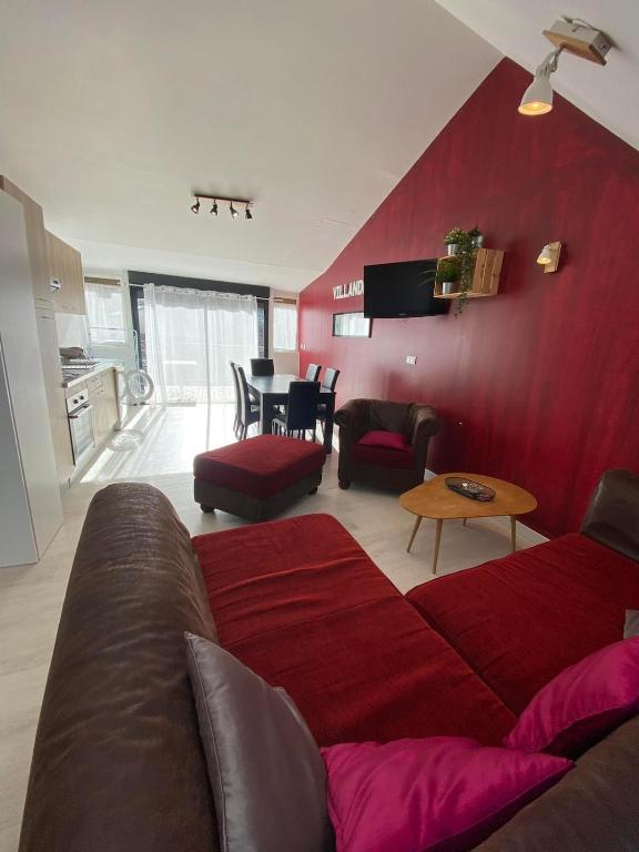 a living room with a couch and a red wall at Gîte 3 chambres à Villandry in Villandry