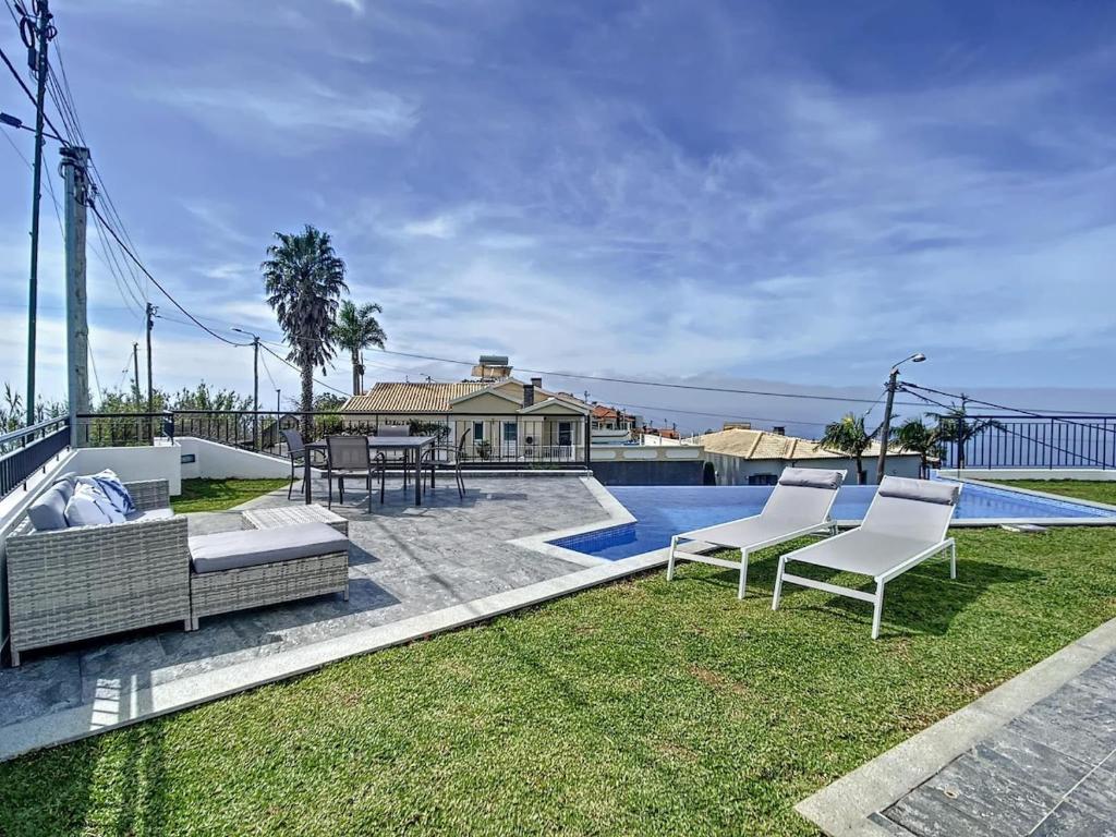 een tuin met twee stoelen en een zwembad bij Zen House By The Madeira Luxury Collection in Arco da Calheta