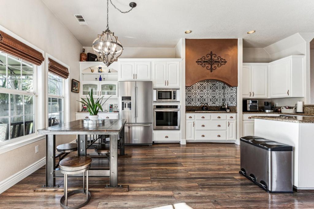 a kitchen with white cabinets and a table and chairs at ¤ Old Folsom La Boheme Artist Retreat + Jacuzzi ¤ in Folsom