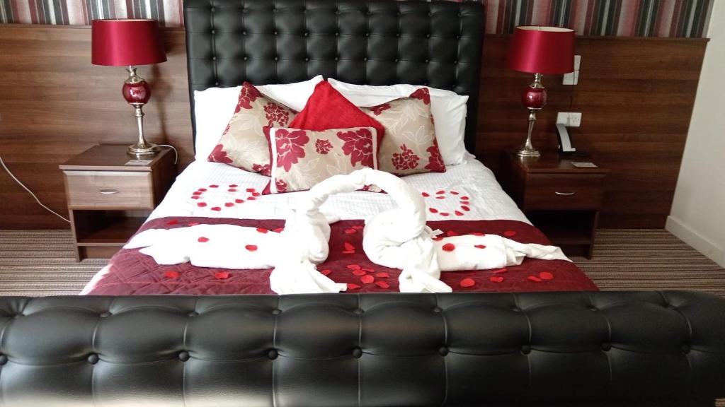 a bedroom with a bed with two swans on it at The Hedges Hotel in Stranocum