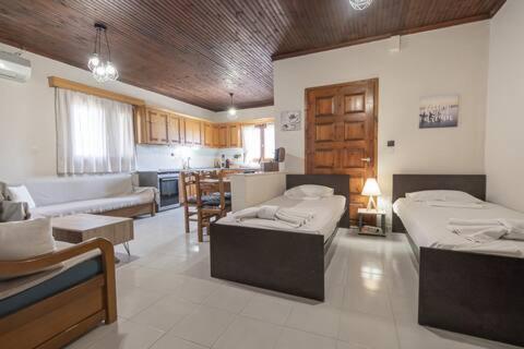 ein Wohnzimmer mit 2 Betten und eine Küche in der Unterkunft Dimis Right House in Sozopoli
