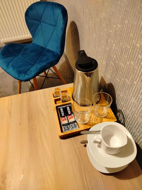 a table with a coffee pot and glasses on it at Hotelik Krakowiak in Jarosław