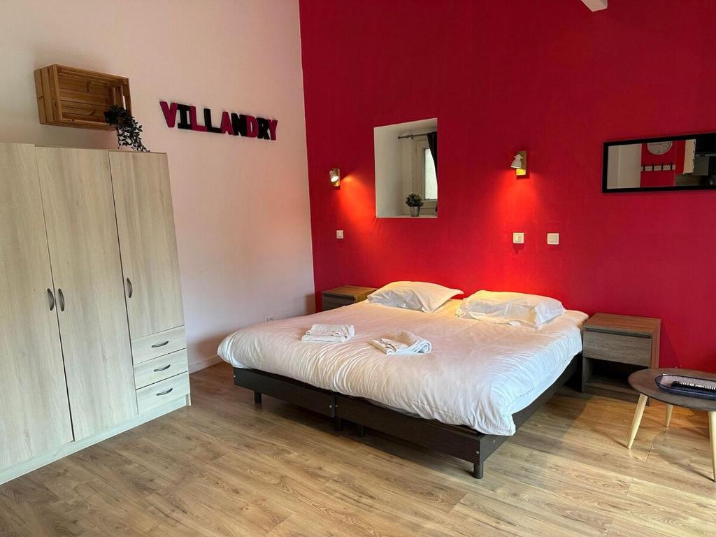 a bedroom with a large bed with a red wall at Studio 2 personnes Villandry avec jardin in Villandry